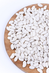 Raw white beans on the kitchen board. Copy space white backgroun