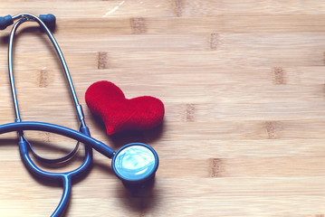 Red heart and a stethoscope on wood background. take care of heart Concept.