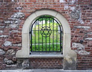 The Old historic Jewish Remuh Cemetery in Kazimierz district in Krakow, Poland, established in 1535, viewed through the grille with the Star of David