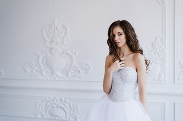 Girl shows hairstyle. Cheerful bride holding her curly hair.