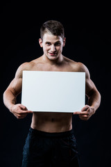 Full isolated studio picture from a young naked man with white sign board. 