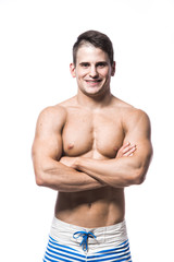 Portrait of a handsome young muscular man in swimwear with hands folded isolated on white background