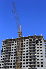 Fototapeta na wymiar build tall buildings for residents. standing next to a construction crane. blue sky