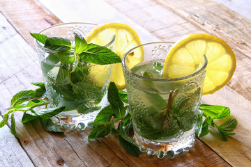 fresh mojito and sliced lemons on a rustic table