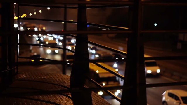 Many cars with lights on driving slowly on interstate road, heavy traffic
