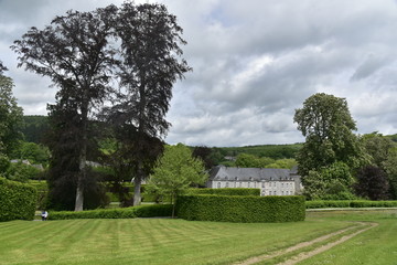 Obraz premium Le haut des Jardins d'Eau d'Annevoie avec le château de Rouillons en contre-bas sous un ciel chargé 