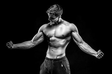 Fototapeta na wymiar Stunning muscular man showing perfect abs, shoulders, biceps, tr