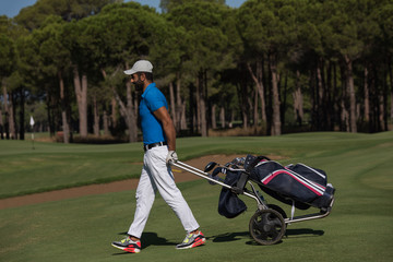 golf player walking with wheel bag