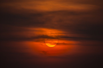 Summer sunset. The setting sun in a cloudy sky background.