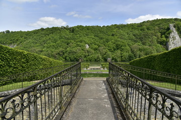 Fototapeta na wymiar La passerelle rustique séparant le pavillon rococo et le jardin au château de Freyr à Hastière