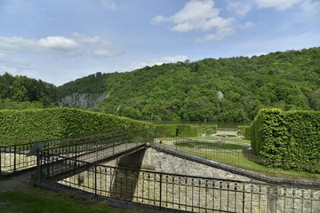 Fototapeta na wymiar La passerelle traversant l'ancienne ligne de chemin de fer et les jardins du château de Freyr à Hastière