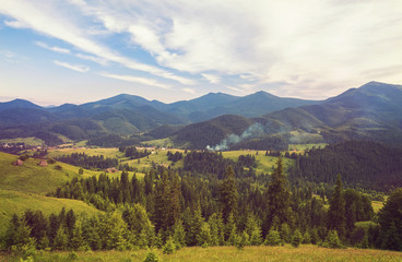 Summer landscape in mountains and the dark blue sky with clouds. Retro color.