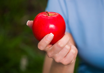 Red apple in hand.