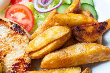 Pork chops, potato wedges and salad