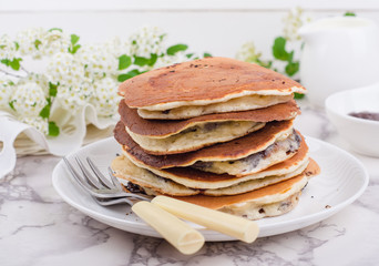 Stuffed chocolate pancakes on n vintage slate chalk board background with flowers and coffee cup....