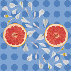 Grapefruit Against the background of circles and white flower petals on blue background