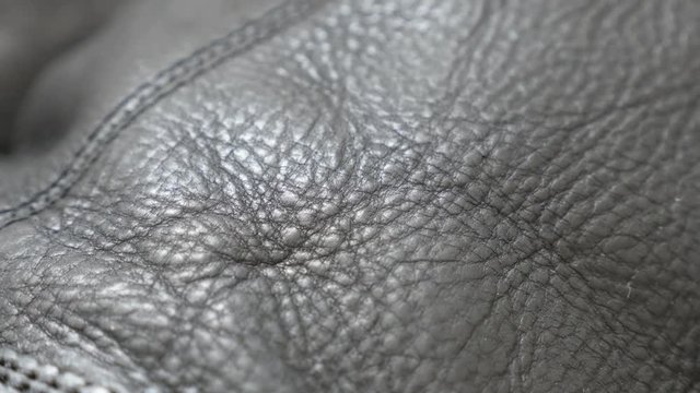 Dark black real leather texture and stitches of modern footwear slow tilt 4K 2160p 30fps UltraHD video - Shallow DOF of real leather surface close-up 4K 3840X2160 UHD tilting footage 