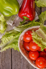 Tomatoes, lettuce, sweet pepper on a wooden board. Rustic.