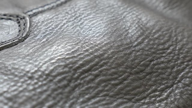 Black real leather texture and stitches of modern footwear slow tilt 4K 2160p 30fps UltraHD video - Shallow DOF of real leather surface close-up 4K 3840X2160 UHD tilting footage
