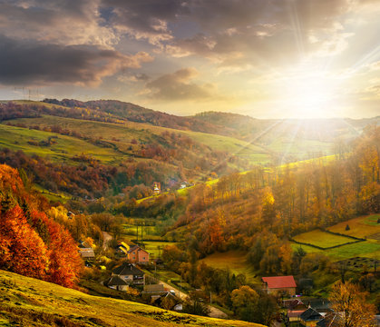 village falls on hillside with autumn forest in mountain at suns