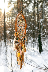 Handmade colorfull dream catcher in the snowy forest