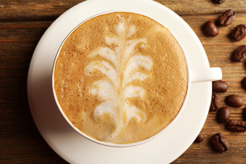 Cup of latte art coffee with grains, closeup