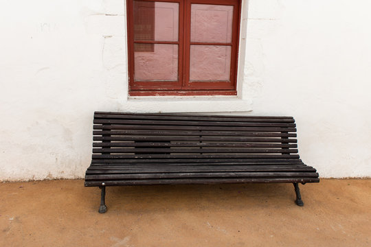 black benche in street with window