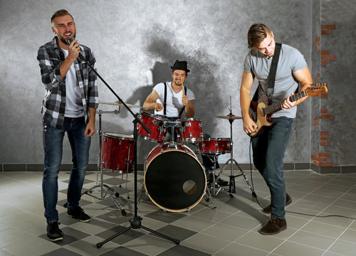 Musicians playing musical instruments and singing songs in a studio