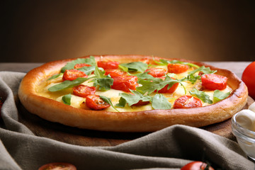 Pizza Margherita with arugula on brown background