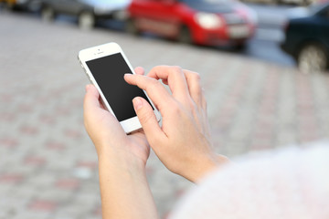 Woman holding smartphone outside