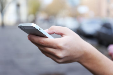 Woman holding smartphone outside