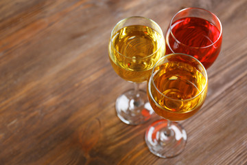 Glasses with wines of different colors on a wooden table