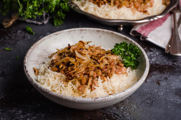 Mujadarra - arabian dish with rice, lentils and onion on dark  background. Ramadan food. Eastern cuisine. Selective focus