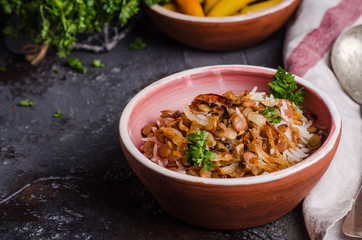 Mujadarra - arabian dish with rice, lentils and onion on dark  background. Ramadan food. Eastern cuisine. Selective focus