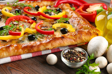 Freshly homemade pizza on wooden table closeup