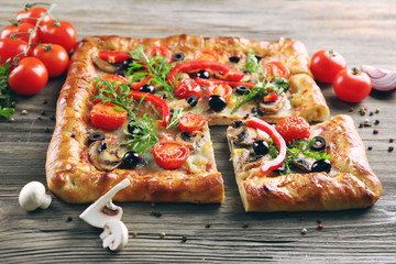 Freshly homemade pizza on wooden table closeup