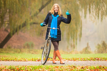 Obraz premium Happy active woman with bike in autumn park.