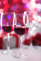Wineglasses on red blurred lights background