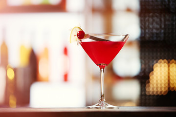 Glass of cocktail on bar background
