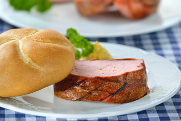 Portion bayerischer, warmer Leberkäs mit knuspriger Semmel und Senf - Portion of warm Bavarian meat loaf with a crispy roll and mustard 