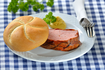 Portion bayerischer, warmer Leberkäs mit knuspriger Semmel und Senf - Portion of warm Bavarian meat loaf with a crispy roll and mustard