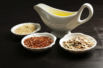 Different kinds of seeds and oil on wooden table