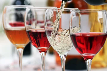 Photo sur Plexiglas Vin White wine pouring into glasses, closeup