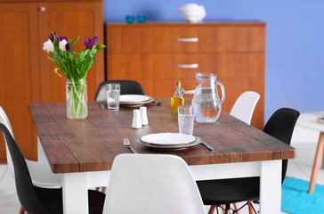 Modern living room. Furniture set with table and chairs. Bouquet of beautiful white and purple tulips on the table