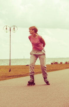 Girl skating alone on seafront.