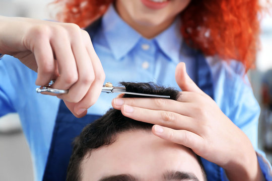 Professional hairdresser making stylish man haircut