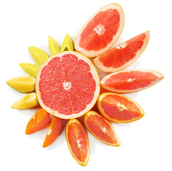 Fresh mixed citrus fruit slices around halved grapefruit on a white background, top view