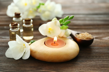 Obraz na płótnie Canvas Spa set with sea salt, flowers and candles on wooden background