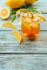 Glass of ice lemon tea on wooden table