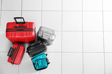 Different suitcases on tile floor, top view